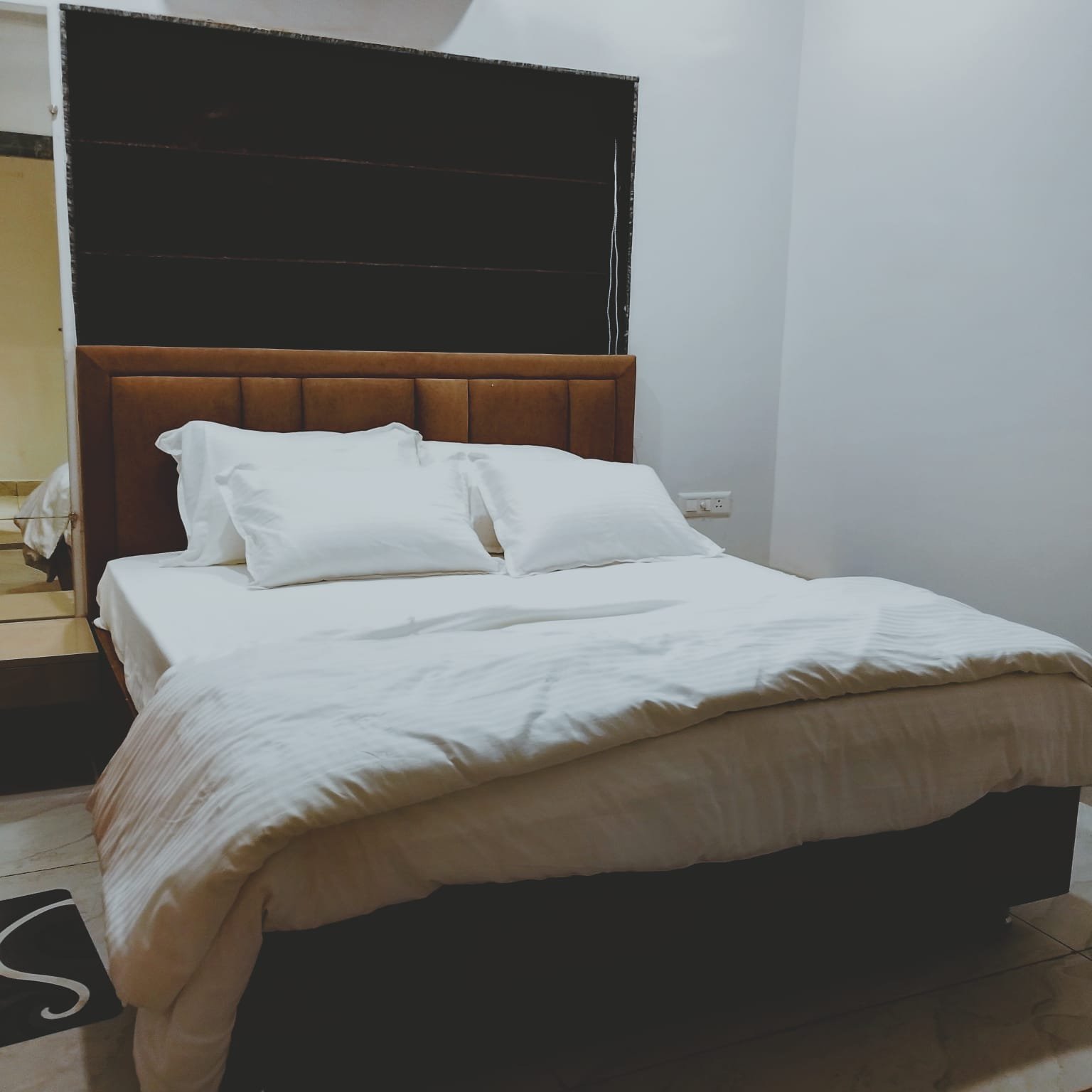 Standard room with cushioned headboard and mirrored wardrobe